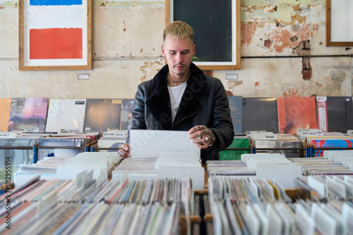 Young man browsing vinyl records in a second hand record store photo