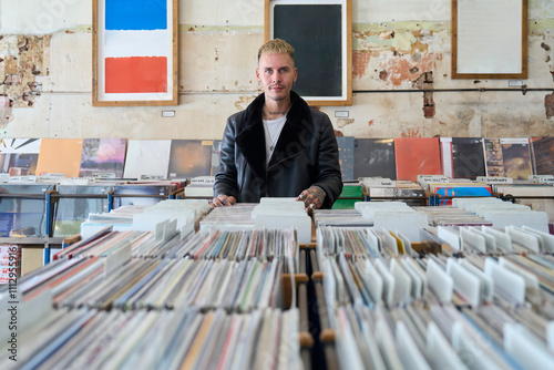 Man exploring a collection of vinyl records in record store photo