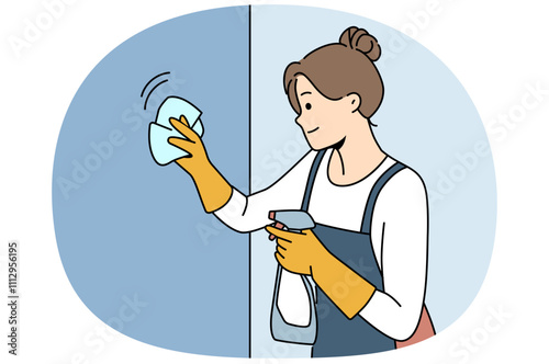 Housewife woman cleaning apartment, wiping wall or glass using antibacterial spray, dressed in apron and gloves. Happy girl works as maid in motel and cleaning preparing room for arrival of guests