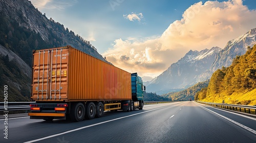  Large orange freight truck driving on highway with mountain scenery, representing logistics and long-haul transportation.