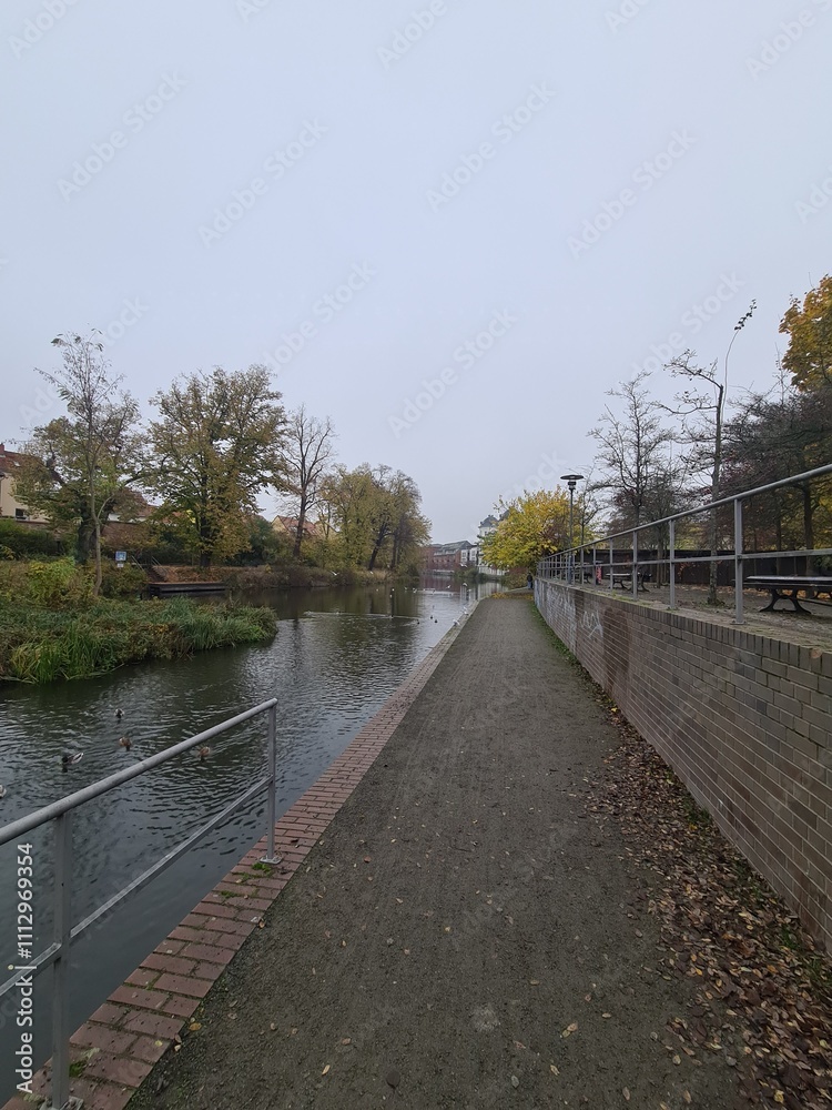 Bürgersteig mit dem Havelfluss auf der linken Seite in Brandenburg an der Havel, an einem atmosphärischen Herbsttag Bürgersteig mit dem Havelfluss auf der linken Seite in Brandenburg an der Havel, an einem atmosphärischen Herbsttag