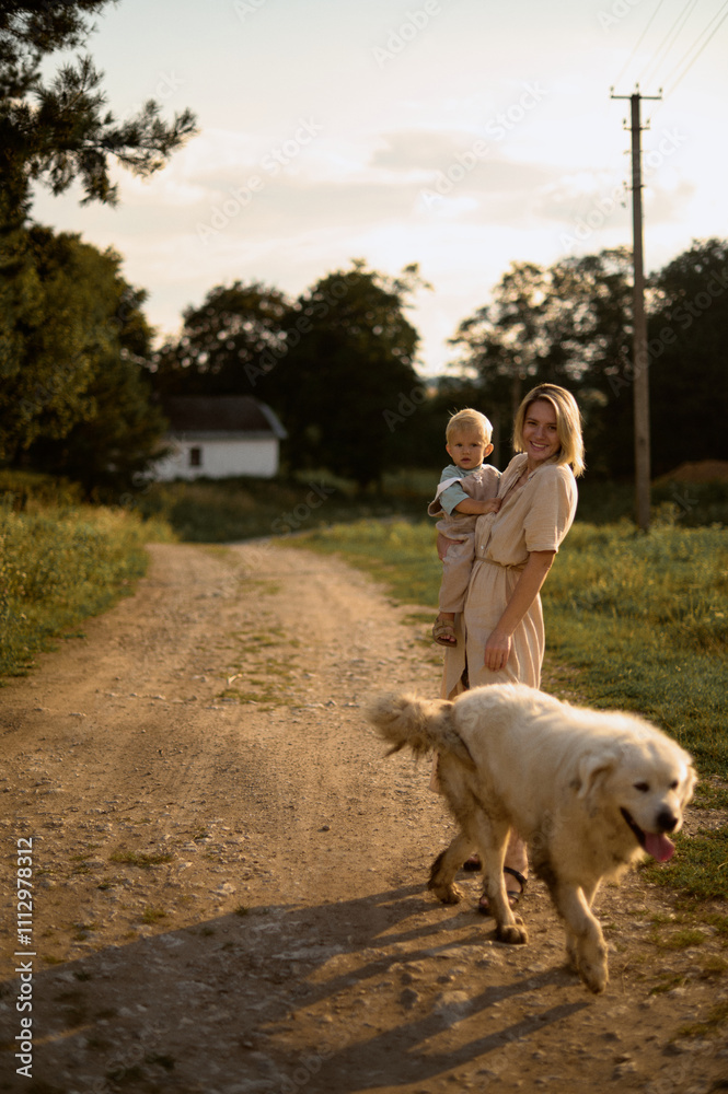 Mother with her son and dog on the village road Mother with her son and dog on the village road