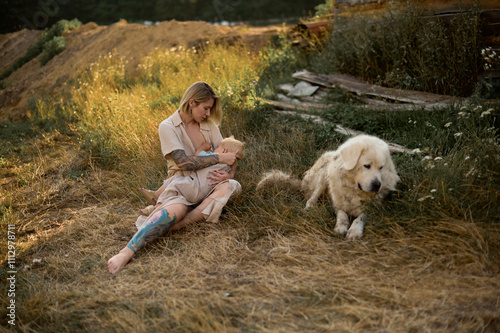 young mom breastfeeds her little son in nature photo