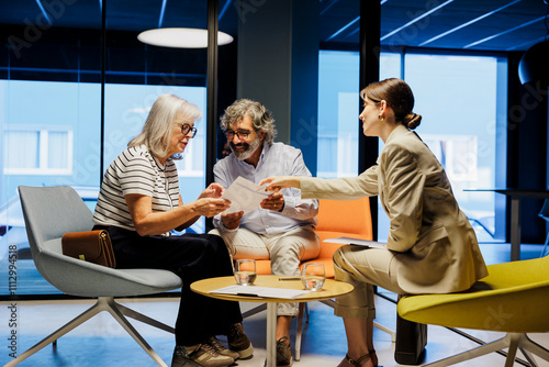 Financial advisor giving investment advice to senior couple in office photo