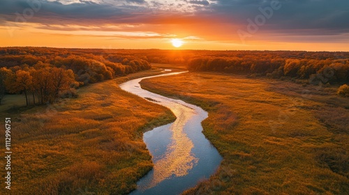 A sunset-lit river winding through golden meadows, viewed from a dronea??s perspective, highlighting autumn colors.