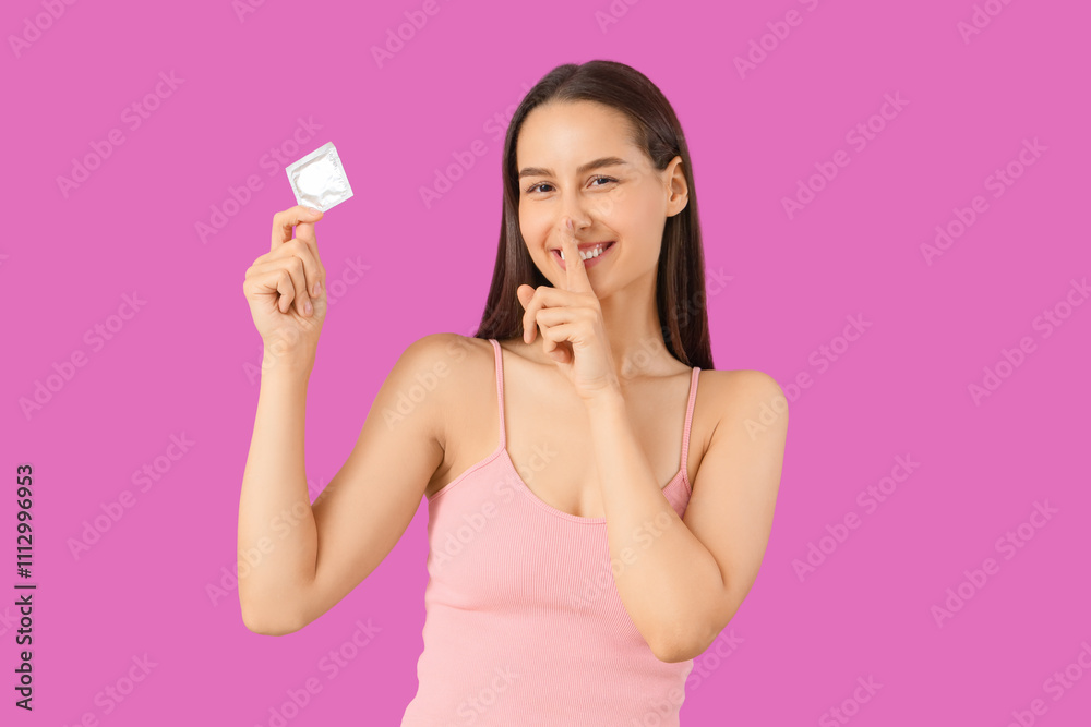 Young woman with condom showing silence gesture on purple background Young woman with condom showing silence gesture on purple background