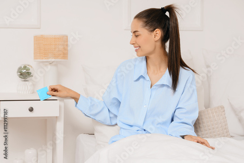 Young woman taking condom f...