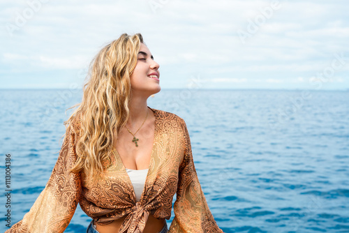 One young blonde and beautiful young woman looking and enjoying summer days in vacation holiday having fun in catamaran boat sailing in the water of sea. photo