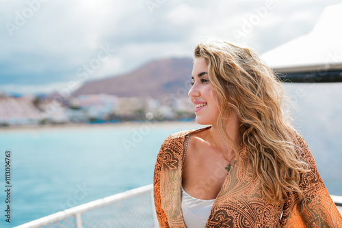 One young blonde and beautiful young woman looking and enjoying summer days in vacation holiday having fun in catamaran boat sailing in the water of sea. photo