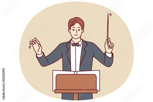Man conductor participates in acoustic concert and helps orchestra perform classical symphony for audience of performance. Conductor in formal suit and bow tie coordinates musicians from opera house