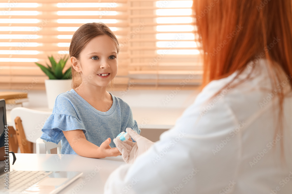 Little girl taking contact lenses from ophthalmologist at table in clinic Little girl taking contact lenses from ophthalmologist at table in clinic