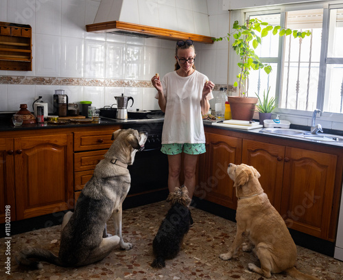 Three dogs waiting for treats in a kitchen.