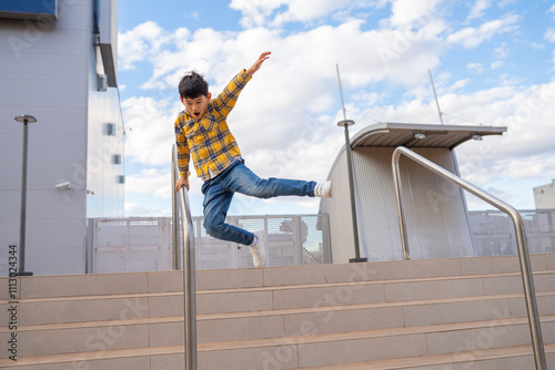 Child jumping off a handrail in an urban area photo