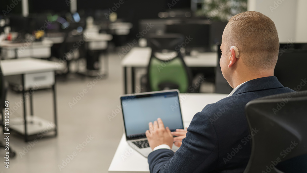 Caucasian deaf man typing on laptop in office. Caucasian deaf man typing on laptop in office.
