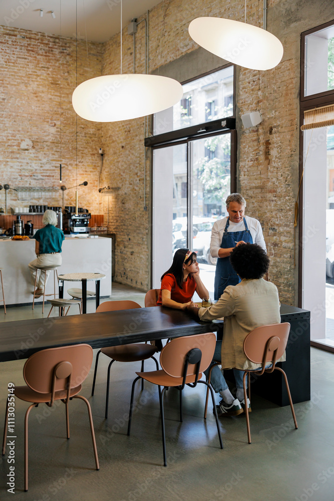 People sitting at tables in modern cafe talking and drinking coffee People sitting at tables in modern cafe talking and drinking coffee
