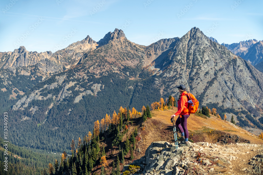 Woman Standing on Rock Lookout with Mountain Peaks in Background Woman Standing on Rock Lookout with Mountain Peaks in Background