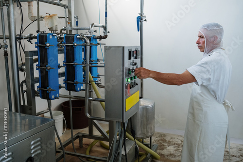Factory worker operating equipment pushing button on control panel