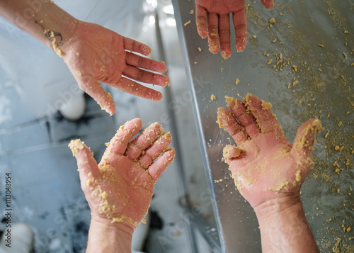 Craftsman showing his hands covered with dough photo