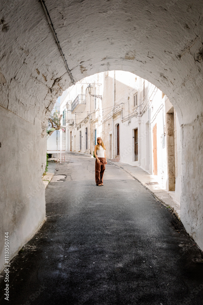 Portrait through archway of a tourist standing in an alley in Italy Portrait through archway of a tourist standing in an alley in Italy