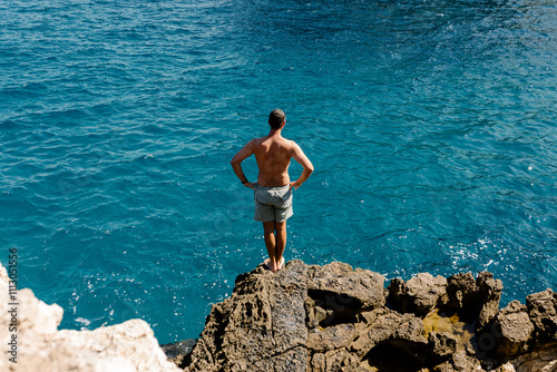 Tourist prepares to jump into sea in the coast of Polignano a Mare