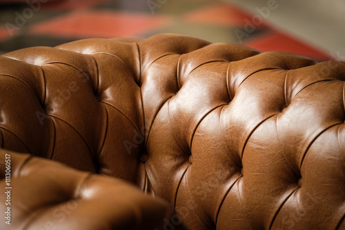 Close-up of tufted brown leather sofa texture in warm light