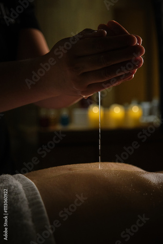 Relaxing spa massage with essential oils in dim candlelight photo