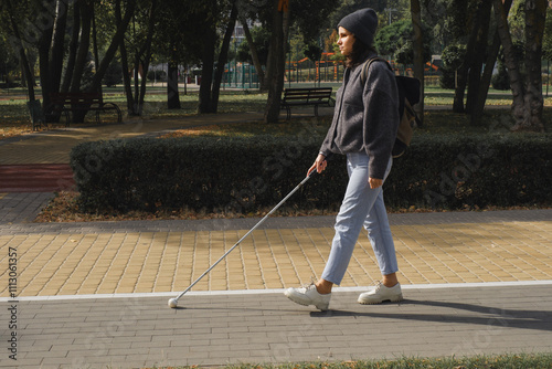 Young woman with visual impairment navigating urban park photo