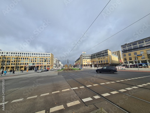 Sicht auf eine Strasse mit Einkaufsgebäuden im Hintergrund, mit atmosphärischem Wolkenhimmel, in Berlin Hellersdorf/Marzahn photo