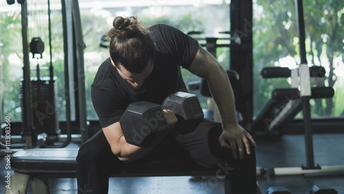 man working out with dumbbell concentration curl
