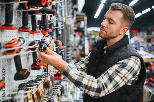 Foto A man chooses a power tool in a hardware store