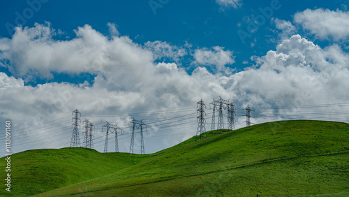 APRIL 2024, CENTRAL CALIFORNIA, USA - multiple electrical towers and green spring grass in Central California  - power grid