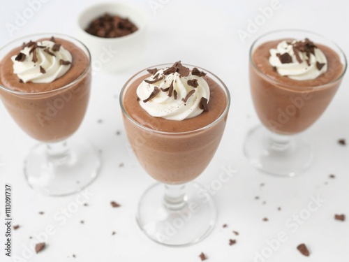 A cozy arrangement of fluffy marshmallows dusted with cocoa powder, placed beside a cup of hot cocoa with whipped cream. White background, minimalistic holiday setup, warm tones.