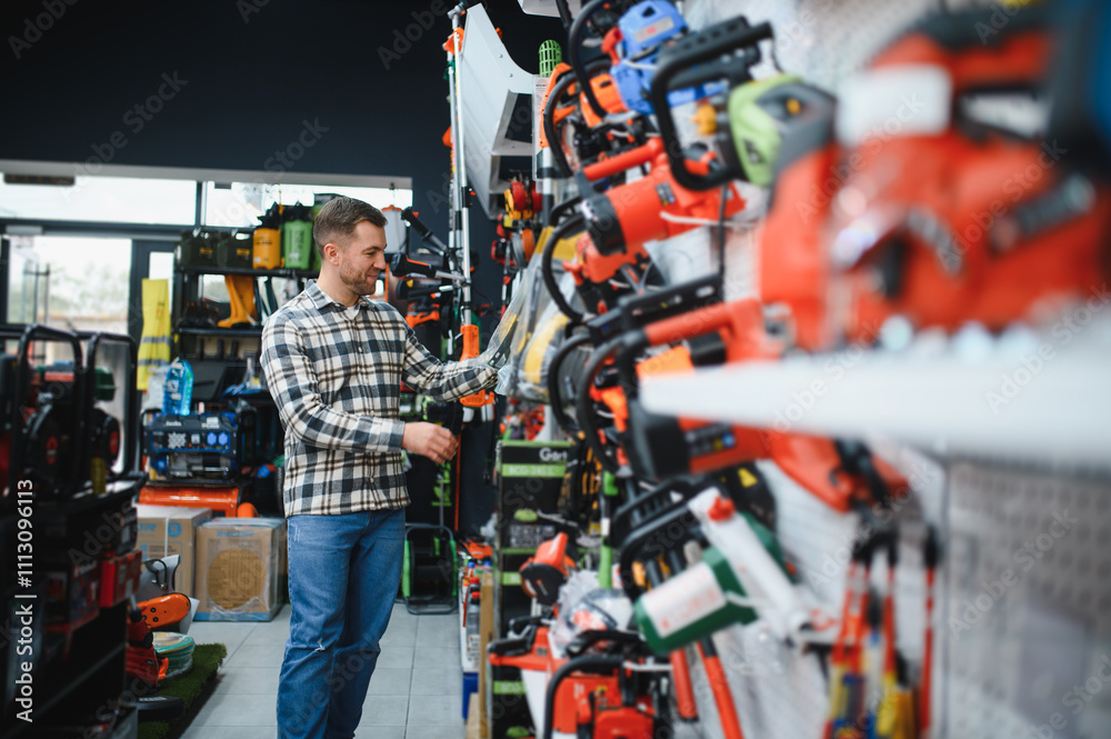 Fototapeta premium A man in a hardware store choosing a tool
