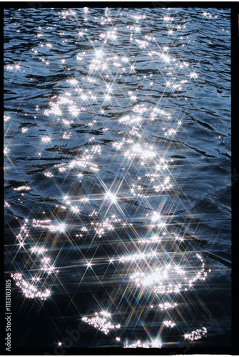 Sparkling sunlight reflection on serene water surface during daytime
