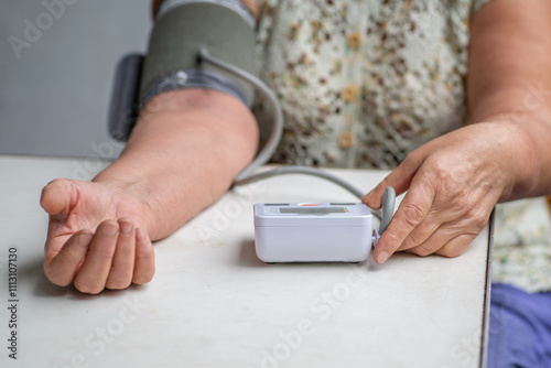 Anonymous  woman measures her blood pressure with a tonometer