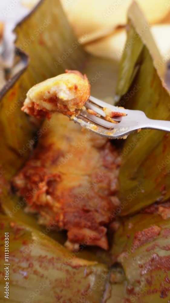 Pedazo de tamal tipo oaxaqueño en tenedor, desayuno rojo