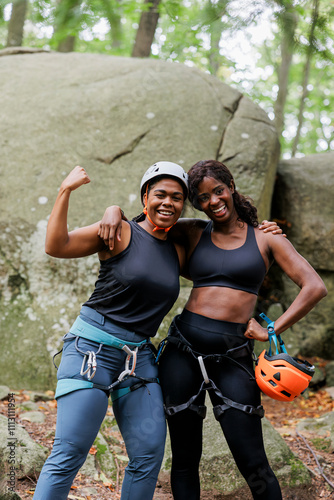 Two female climbers smiling before climbing a rock face photo