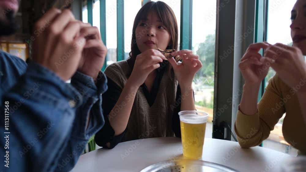 Friends enjoying pizza and beer at casual restaurant table Friends enjoying pizza and beer at casual restaurant table