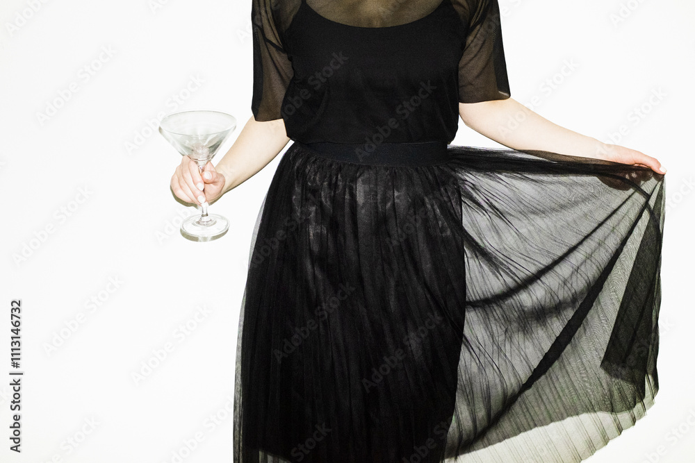 © Colour Laboratory/Stocksy - Person with balck fashion festive party dress holding a cocktail glass © Colour Laboratory/Stocksy - Person with balck fashion festive party dress holding a cocktail glass