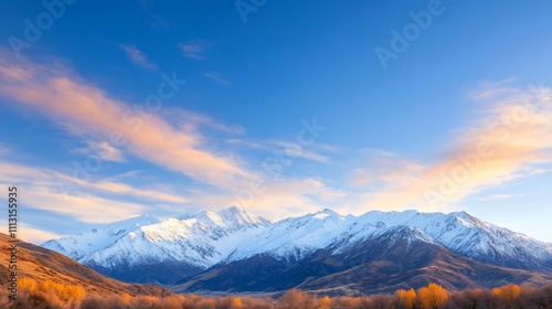 Scenic mountain landscape with snow-capped peaks and blue sky.