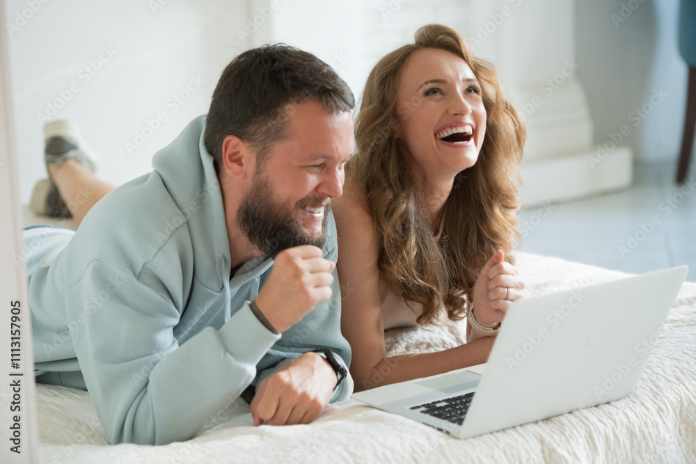 joyful happy couple on bed with laptop joyful happy couple on bed with laptop