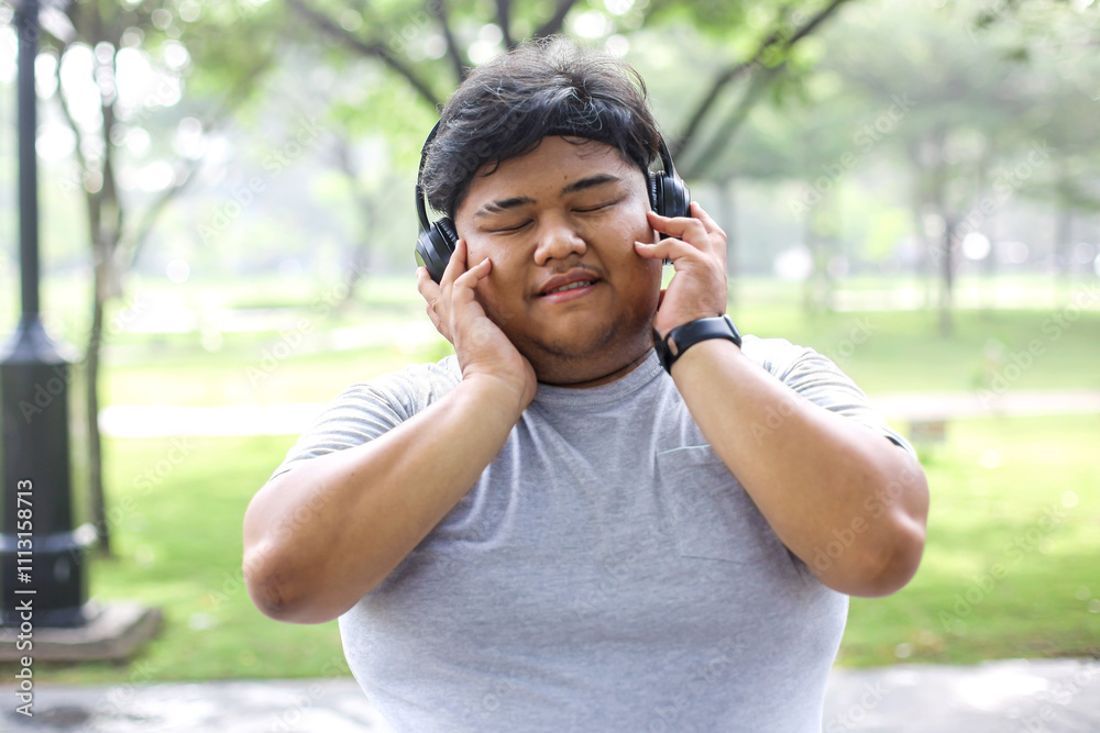 Portrait Of Fat Man Enjoying Music Wearing Headphones In The Park Portrait Of Fat Man Enjoying Music Wearing Headphones In The Park