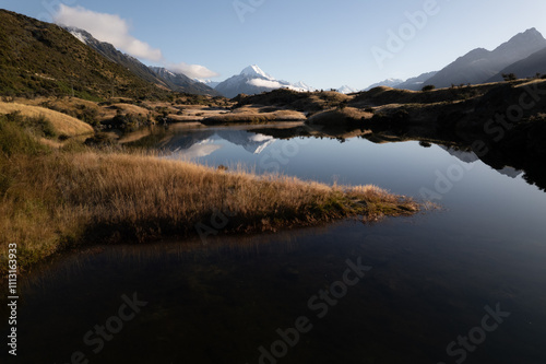 A Snow Capped Mountain Peak reflected on the Surface Of A Small Lake photo