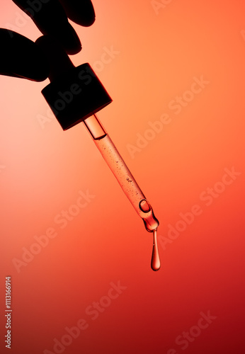 Hand holding dropper bottle with anti aging face serum.