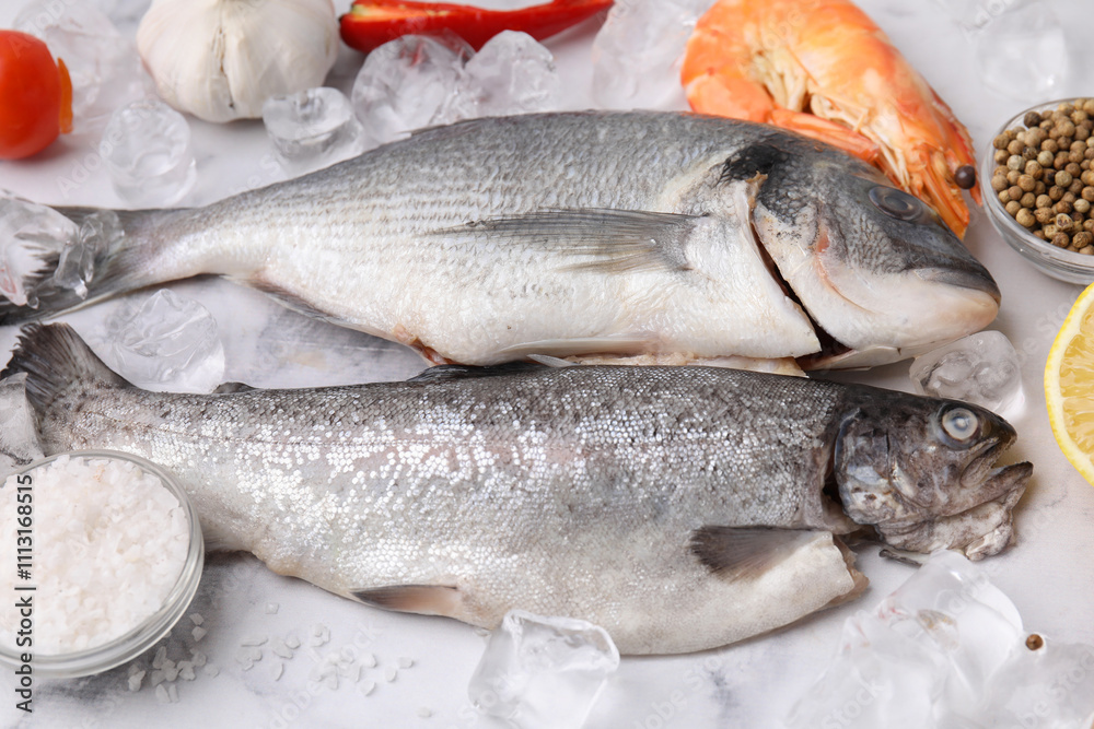 Fresh raw sea food, ice cubes and products on white marble table Fresh raw sea food, ice cubes and products on white marble table