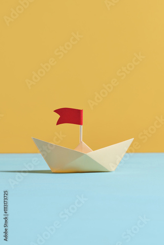 Origami yellow paper boat on pastel color background photo