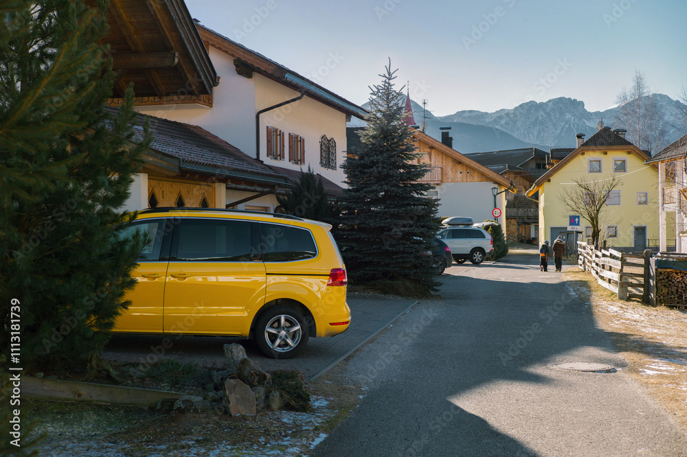 A yellow car is parked next to a Chalet-style house A yellow car is parked next to a Chalet-style house