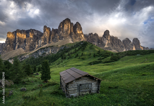 Small hut and Dolomites mountain range during sunset photo