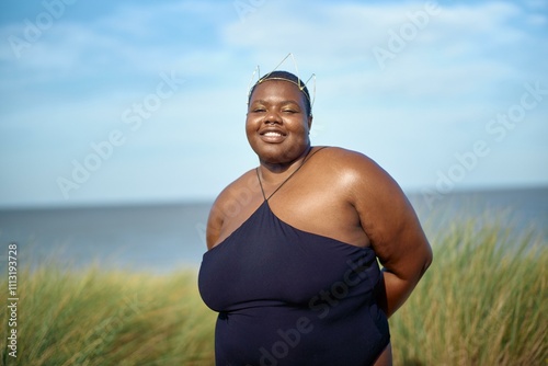 Joyful woman wearing a crown near tranquil waters photo