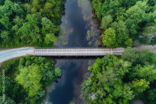 Aerial view of a wooden bridge over a river in a lush green forest.